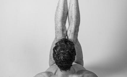 Nude figure doing a shoulder stand