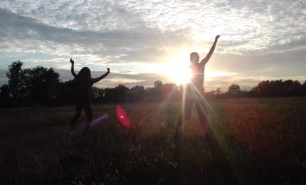 two girls dancing in a field. 